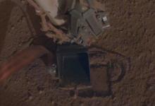 宇航局洞察号火星车在尘土飞扬的火星景观中挖出它的鼹鼠